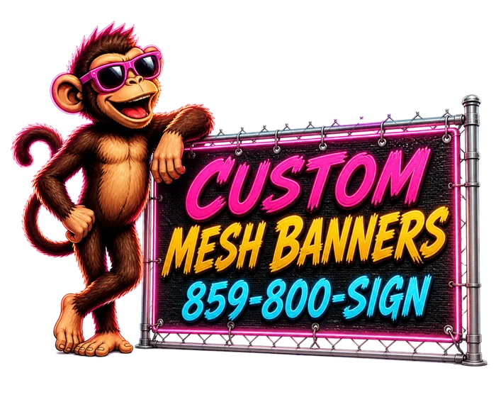 Billboard Monkey mascot leaning on a custom mesh banner mounted on chain-link fencing
